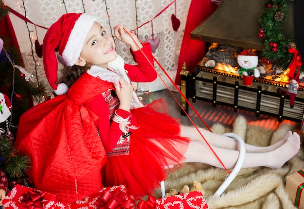 Glückliches Kindermädchen mit einem Weihnachtsgeschenk