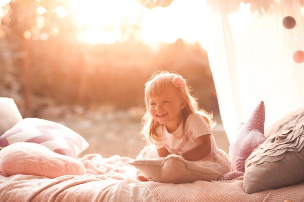 Glückliches Kindermädchen wacht im Bett auf