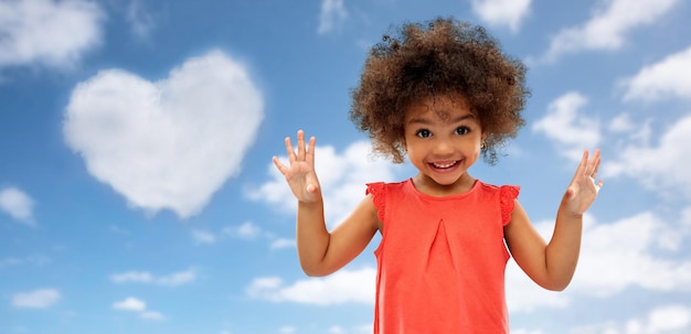 Foto glückliches kleines afroamerikanisches mädchen über blauem himmel