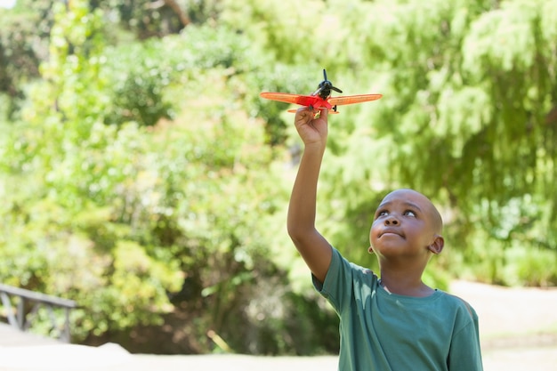 Glückliches kleines Jungenfliegen-Spielzeugflugzeug