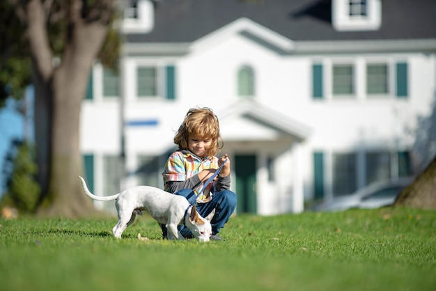 Glückliches kleines Kind, das mit Hund im Garten spielt, Haustiere und menschliche Freundschaft