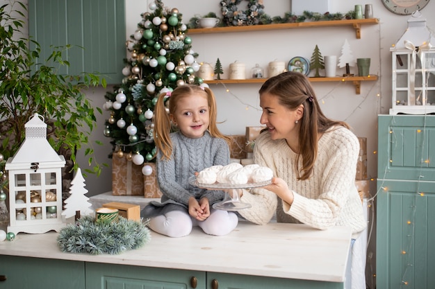 Glückliches kleines Kind mit Mutter in der Küche zu Hause.