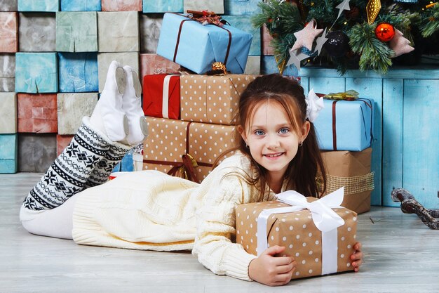 Glückliches kleines lächelndes Mädchen mit Weihnachtsgeschenkbox.