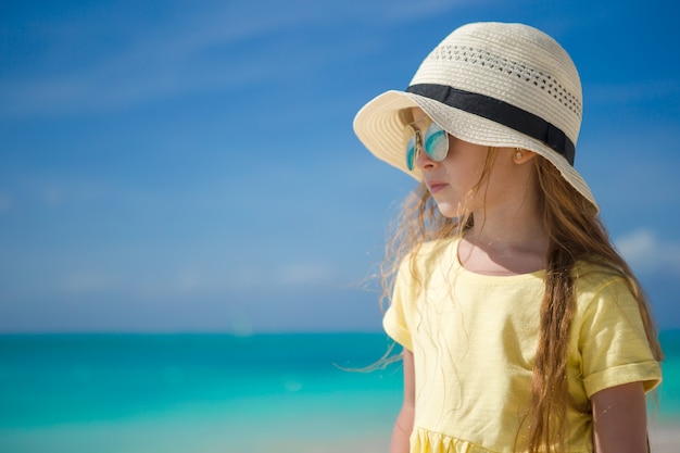 Glückliches kleines Mädchen am Strand während der Sommerferien