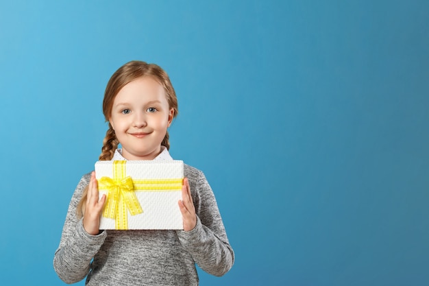 Glückliches kleines Mädchen, das Kasten mit Geschenk hält