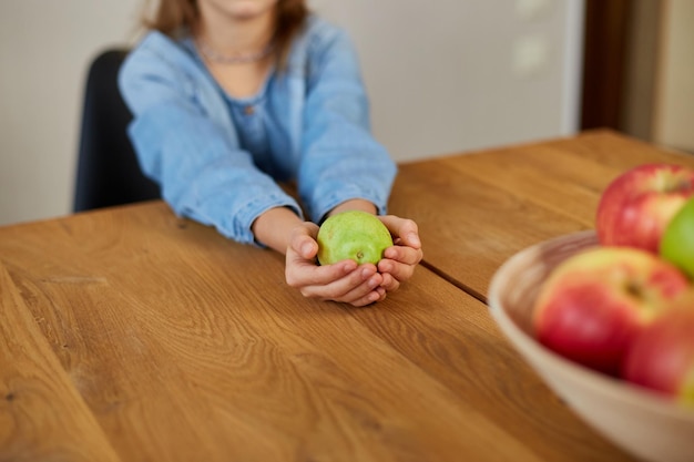 Glückliches kleines Mädchen hält die Birne in der Hand