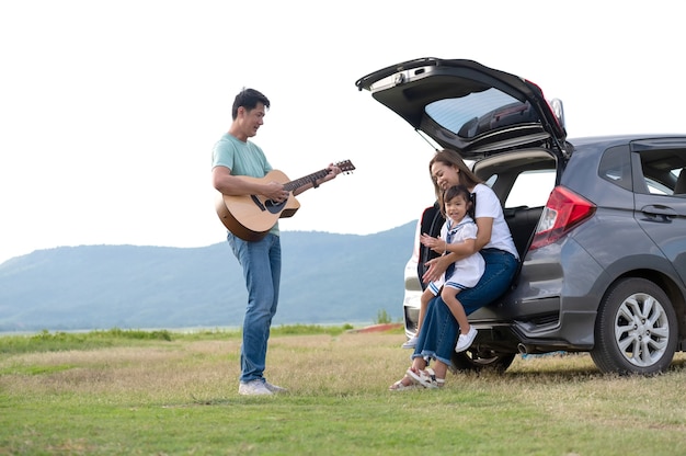 glückliches kleines Mädchen mit der Familie, die im Auto sitzt