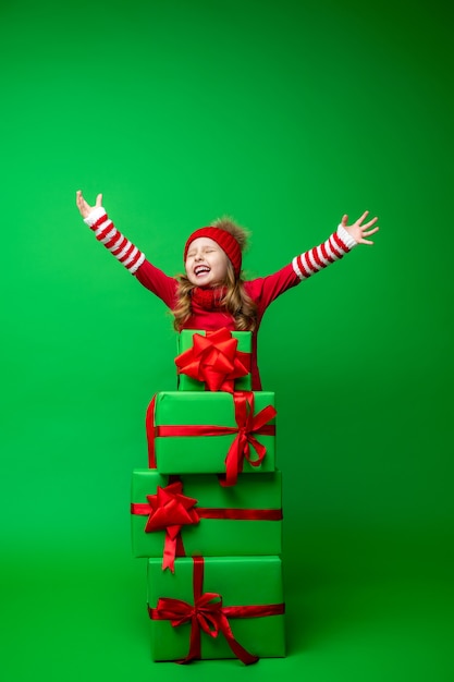 Foto glückliches kleines mädchen mit einem stapel weihnachtsgeschenkboxen