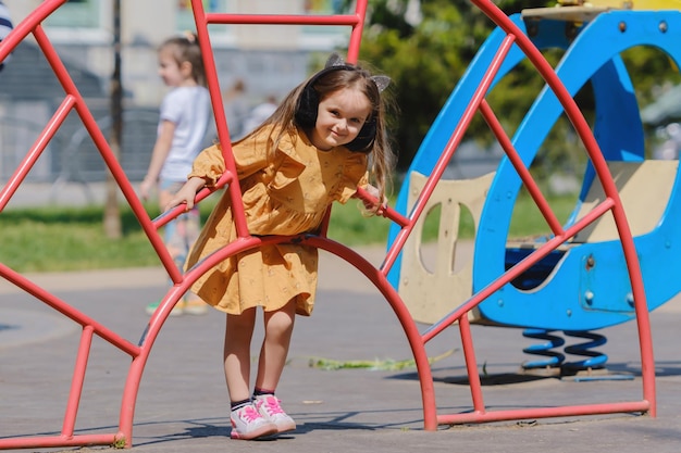 Foto glückliches kleines mädchen spielt auf dem spielplatz im park