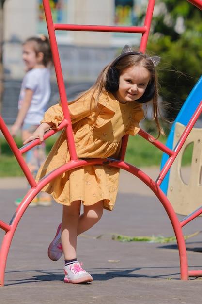 Glückliches kleines Mädchen spielt auf dem Spielplatz im Park