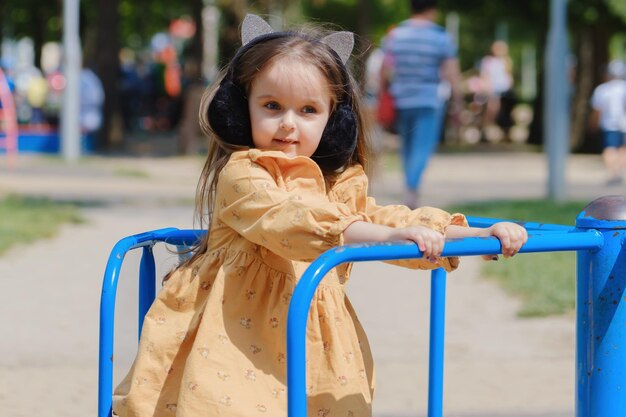 Glückliches kleines Mädchen spielt auf dem Spielplatz im Park