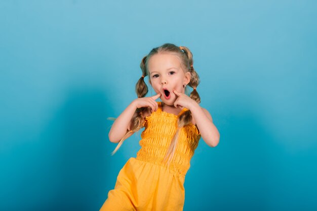 Glückliches kleines Mädchen, Studioaufnahme. Kindergefühle, lächelnd blond.