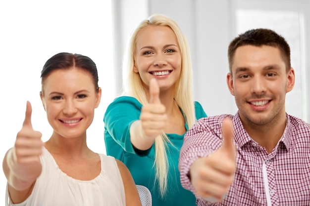 Foto glückliches kreatives team zeigt den daumen nach oben im büro