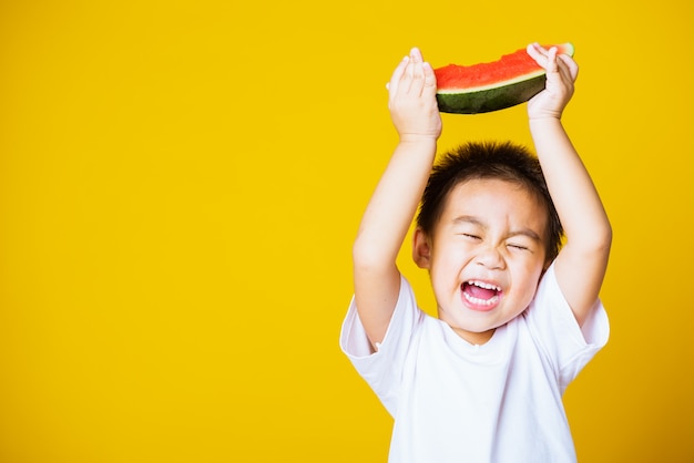 Glückliches Lächeln des kleinen Jungen des asiatischen Kindes hält geschnittene Wassermelone frisch zum Essen