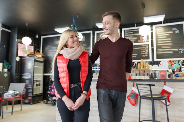 Glückliches lächelndes Paar, das im Kaffeehaus umarmt