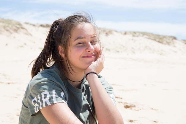 Glückliches lächelndes Teenager-Mädchen im Freien am Sommertag