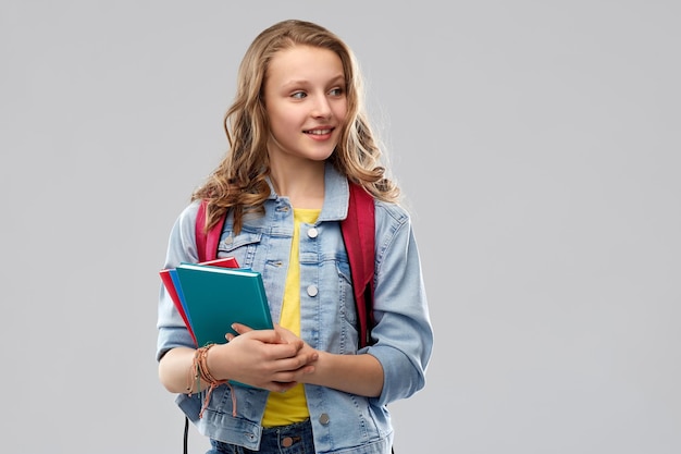 glückliches lächelndes Teenager-Studentenmädchen mit Schultasche