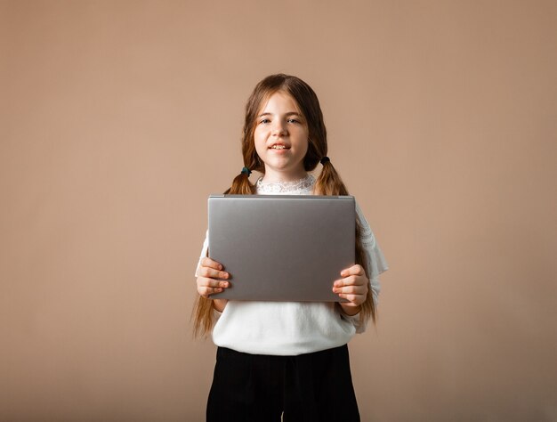 Glückliches Mädchen 12 Jahre alter positiver Schüler, der mit Laptop-Computer zur Schule geht