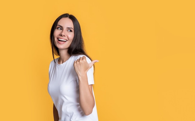 Glückliches Mädchen, das Daumenfinger zeigt Mädchen, das Produkt für Werbebanner präsentiert
