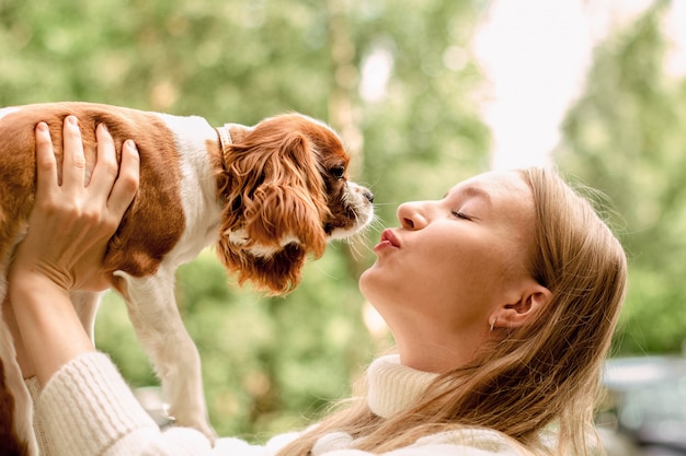 Glückliches Mädchen, das niedlichen Spanielwelpen hält