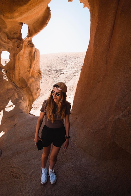 Glückliches Mädchen, das während seines Urlaubs die Felsformationen der Las Penitas-Schlucht auf Fuerteventura erkundet