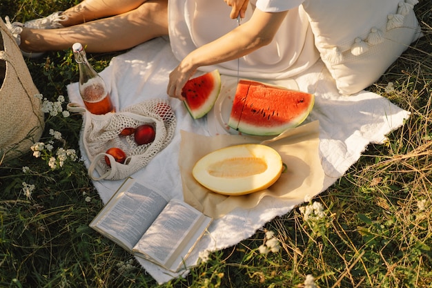 Glückliches Mädchen im Park im Freien mit erfrischender Wassermelonenfruchtfrau isst ein Stück Wassermelone