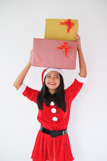 Glückliches Mädchen im Weihnachtsmann-Kleid mit Geschenkbox auf weißem Hintergrund auf Weihnachtsfeier