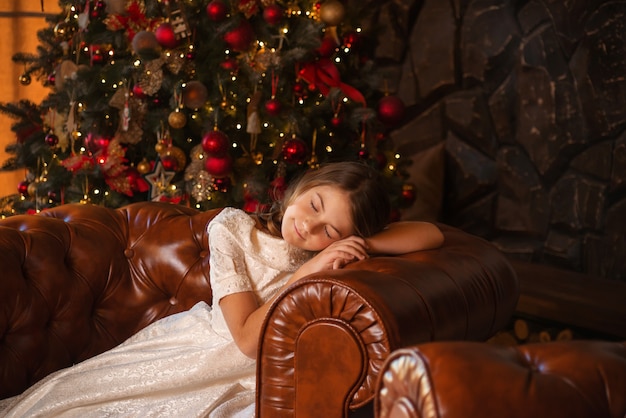 glückliches Mädchen in einem schönen Kleid feiert Weihnachten