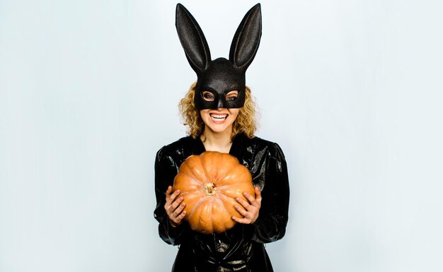 Glückliches Mädchen in Halloween-Hase-Kostüm sexy Frau in Kaninchenmaske mit Jackolantern Halloween-Party