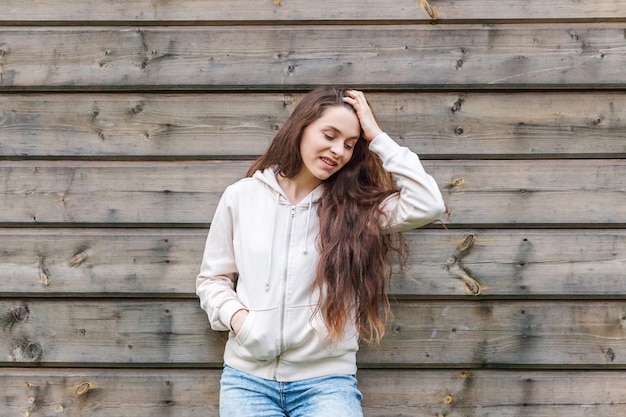 Glückliches Mädchen lächelnd Schönheitsporträt junge glückliche positive lachende brünette Frau auf Holzwandhintergrund