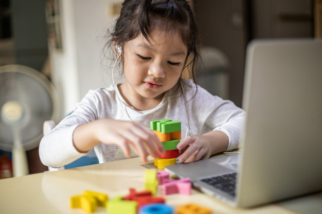 Glückliches Mädchen lernen online mit Laptop zu Hause