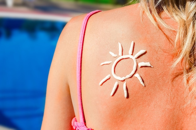 Glückliches Mädchen mit der Sonne auf ihrem Rücken am Pool in der Natur