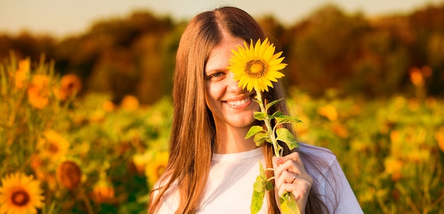 Glückliches Mädchen mit Sonnenblume in der Hand