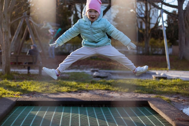 Glückliches Mädchen springt auf einem Trampolin auf der Straße