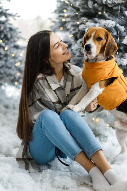 Glückliches Mädchen und Hund zu Weihnachten Ein Mädchen mit einem Beagle in einer Neujahrsatmosphäre