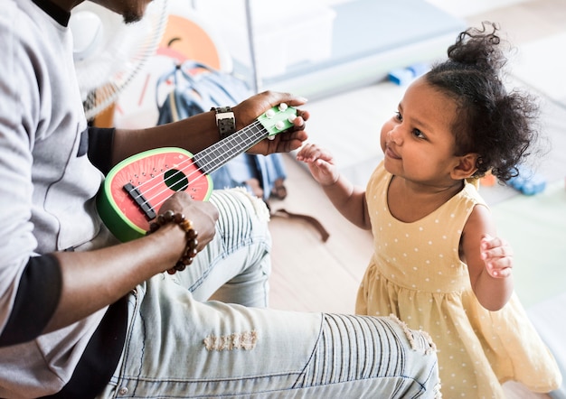 Glückliches Mädchen und Lehrer, die Spaß in der Kindertagesstätte hat