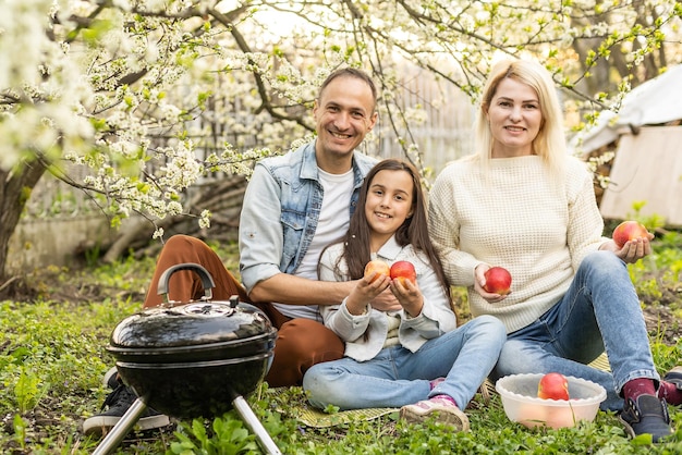 Glückliches Mädchen, Vater und Mutter, die Grill im Hof vorbereiten.