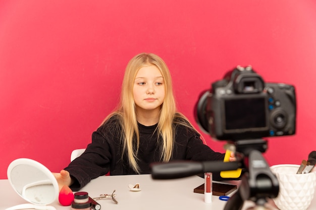 Glückliches Mädchen zu Hause, das vor Kamera für vlog spricht