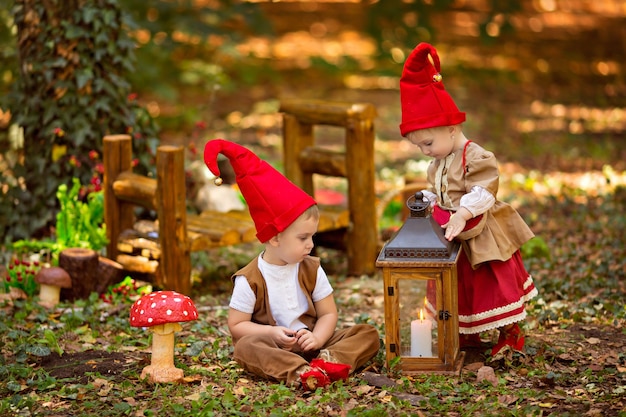 Glückliches märchenhaftes Babygnom-Mädchen und Junge, die im Wald spielen