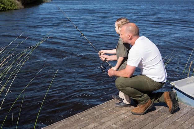 Glückliches Mannfischen mit seinem Sohn