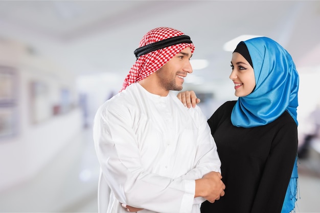 Glückliches muslimisches Paar, das auf hellem Hintergrund lächelt