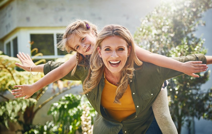 Foto glückliches mutterporträt und piggyback mit tochter für den bindungsurlaub oder wochenende im hinterhof zu hause mutter kind oder kleines mädchen mit lächeln für das fliegen spielen oder unterstützung für den tag im freien zusammen