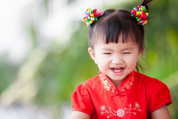 Glückliches nettes asiatisches kleines Kindermädchen beim chinesischen Traditionskleidlächeln