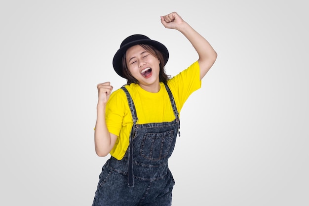 Glückliches nettes asiatisches Mädchen im gelben und schwarzen Hut mit weißem Hintergrund