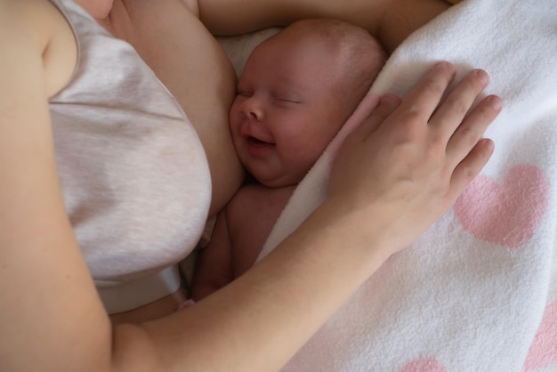 Glückliches neugeborenes Baby füttert Milch auf Mutterbrüsten