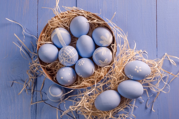 Glückliches Ostern malte Eier auf buntem Holztisch