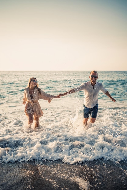 Glückliches Paar am Meer Flitterwochen-Liebhaber Mann und Frau auf der Insel Schönes Paar Spaß an der Küste Glückliches Paar im Urlaub Mann und Frau am Meer