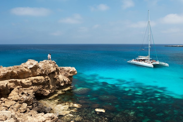 Glückliches Paar am Meer. Flitterwochen-Liebhaber. Mann und Frau auf der Insel. Verliebtes Paar im Urlaub. Ein Gutschein für eine Kreuzfahrt. Hochzeitsreise. Flitterwochen. Glückliches Paar, das sich am Meer küsst