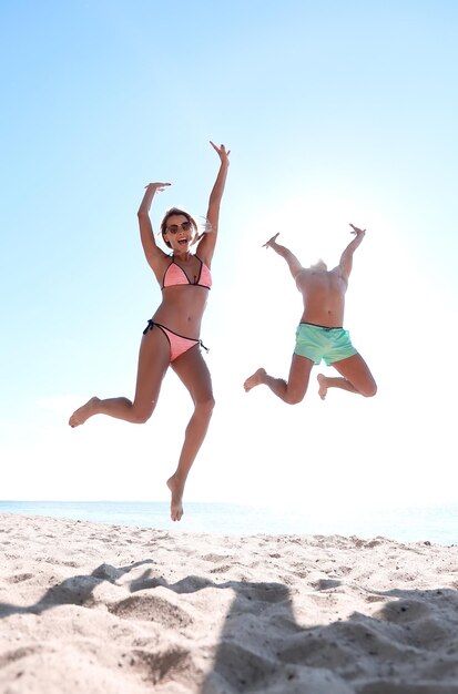 Glückliches Paar am Strand springen