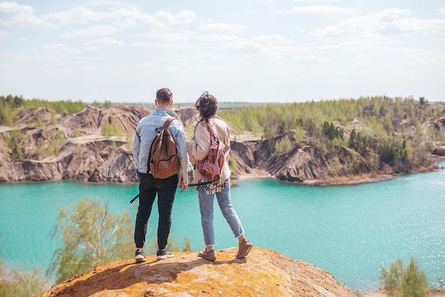 Glückliches Paar auf dem Gipfel des Berges genießen Sie die Aussicht auf den blauen See